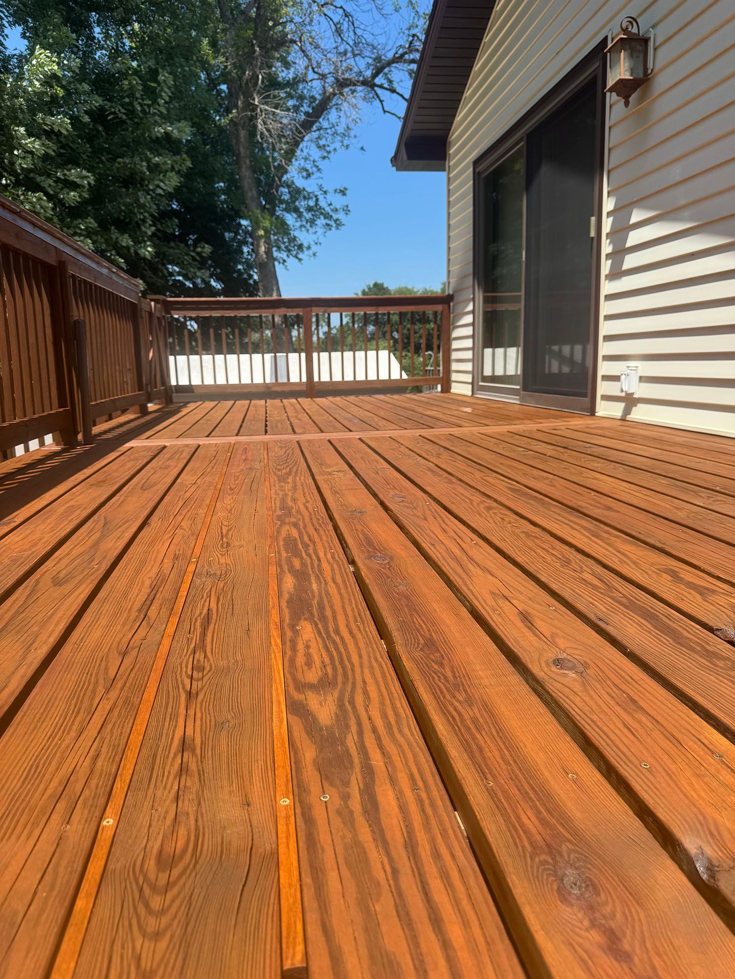 A wooden staircase leading up to a deck with a railing.