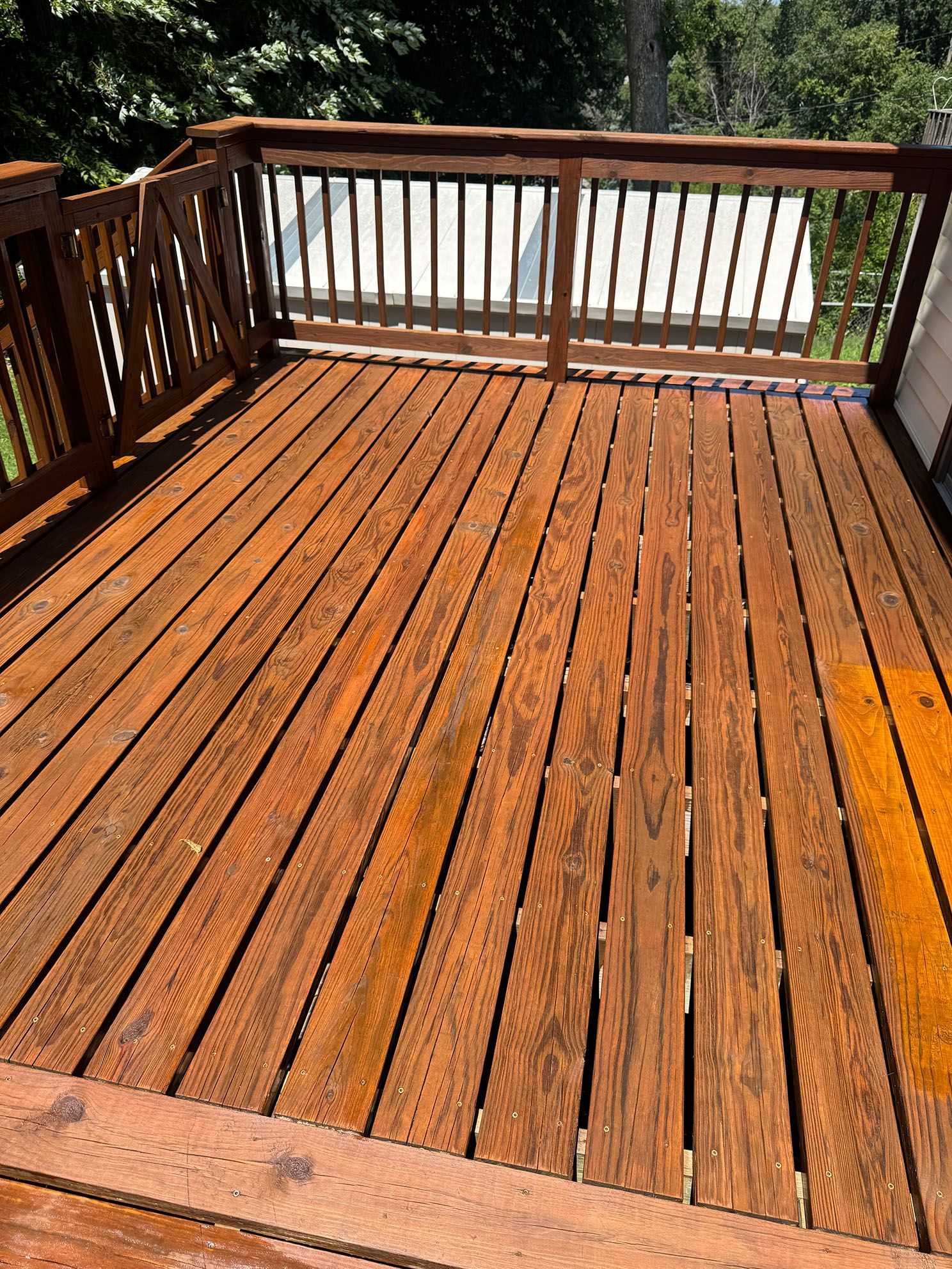 A wooden deck with potted plants and a hose on the side of it.