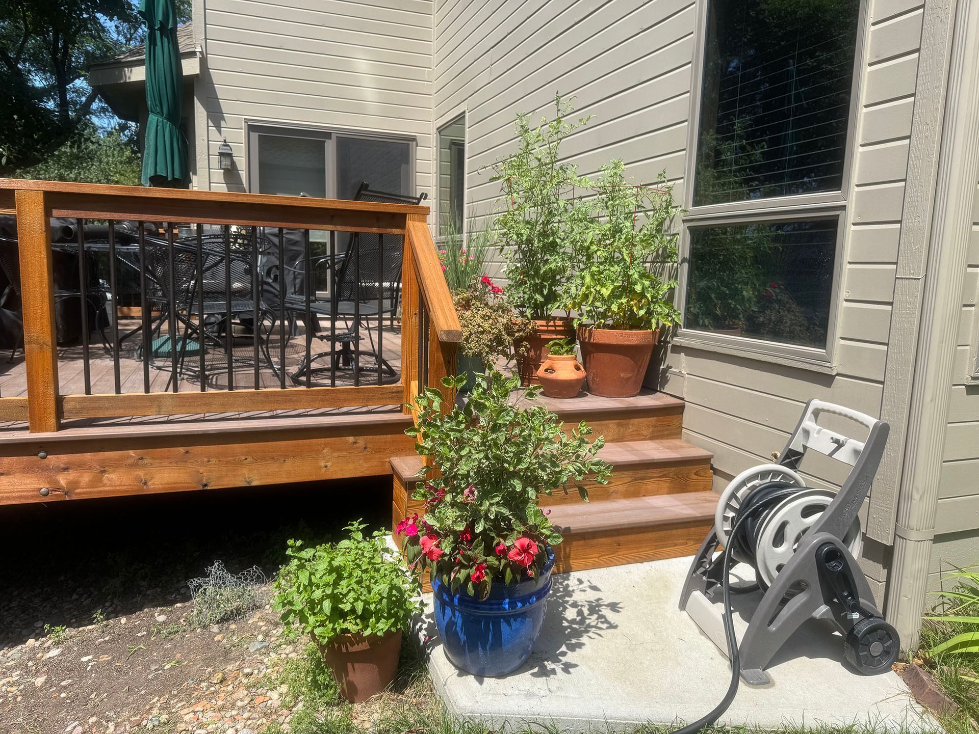 A wooden deck with a railing and trees in the background.