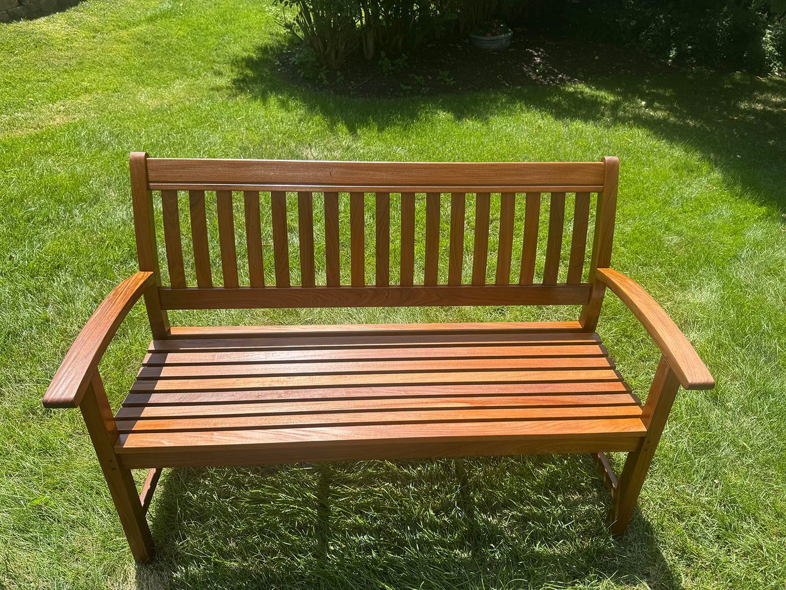 A wooden deck with a table and chairs on it in front of a house.