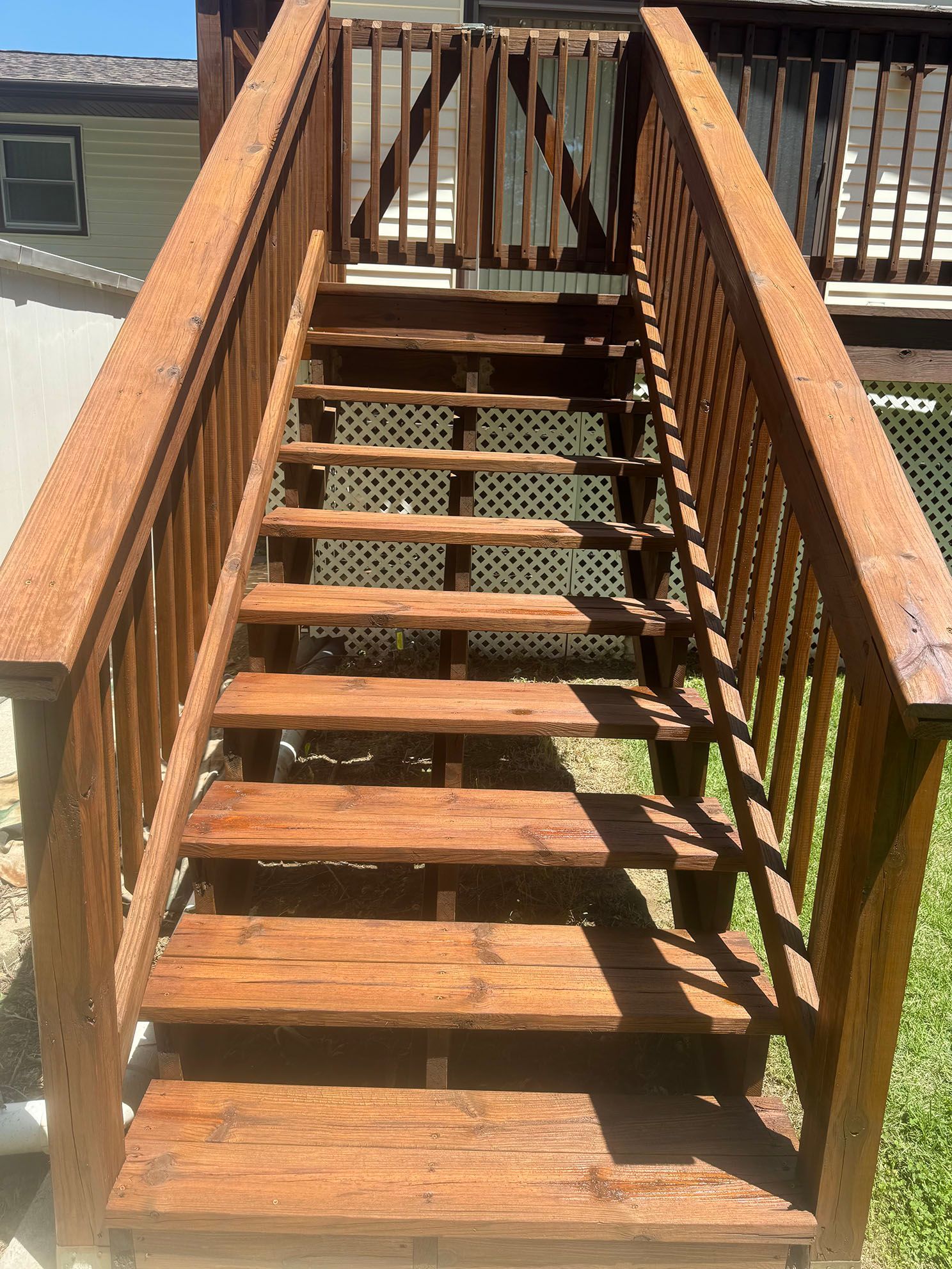 A wooden deck is sitting in front of a house.