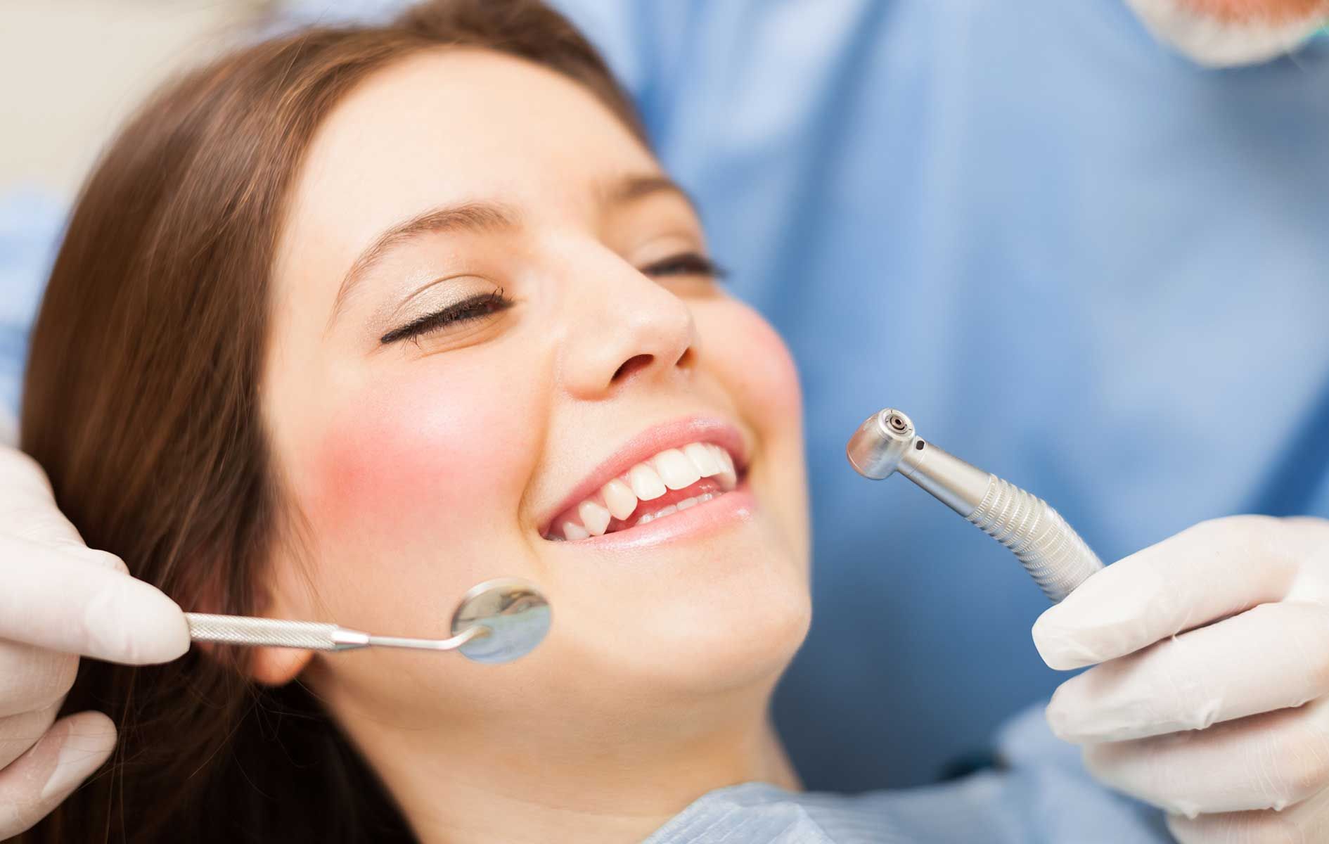 A woman is getting her teeth examined by a dentist.