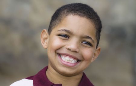 A young boy with braces on his teeth is smiling for the camera.