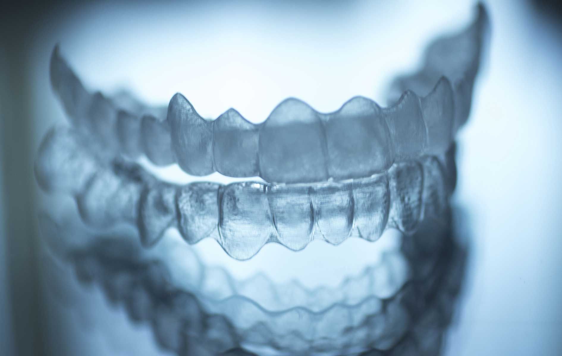 A close up of a pair of clear braces on a person 's teeth.