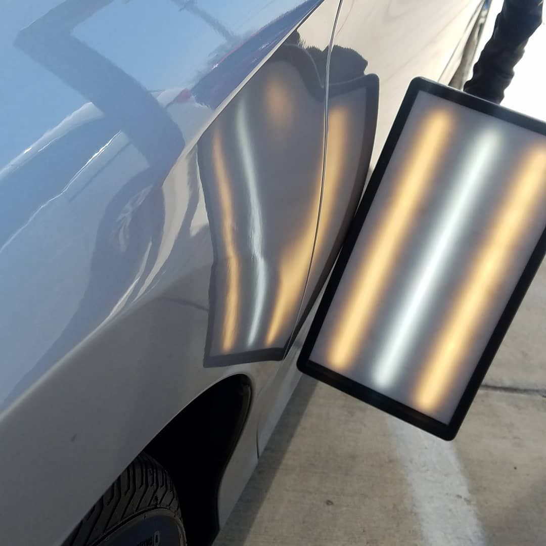 A close up of a car with a dent in it