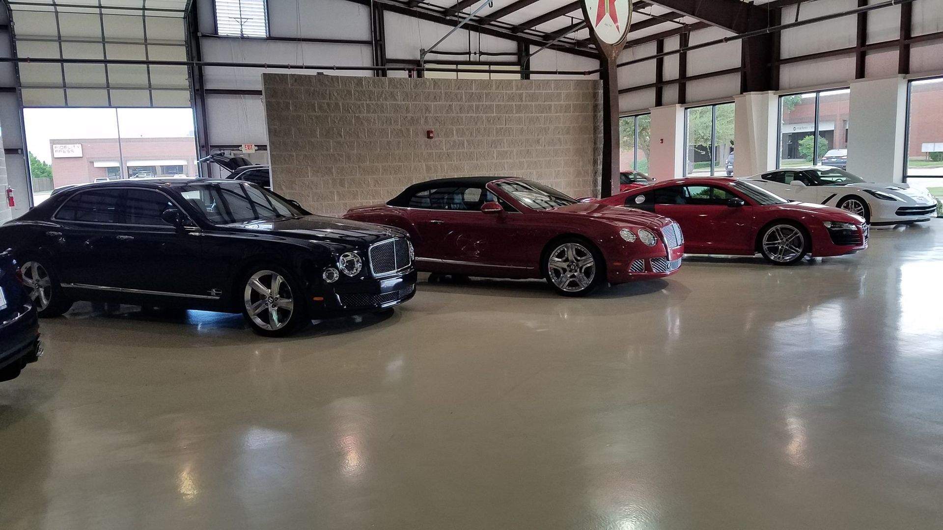 A row of cars are parked in a garage.