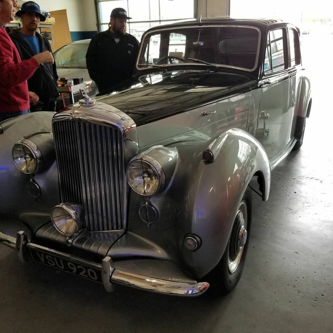 A silver car with a license plate that says bu 920 is parked in a garage.