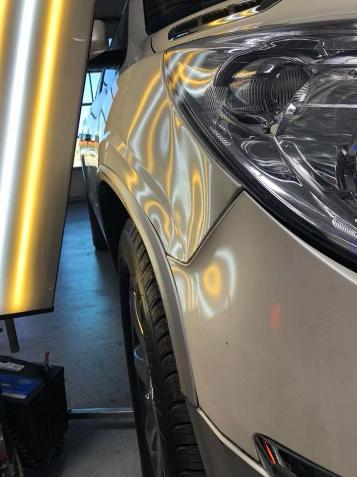 A close up of a car with a dent in the fender.