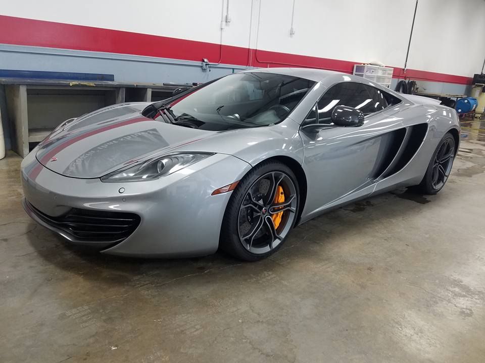 A silver sports car is parked in a garage.
