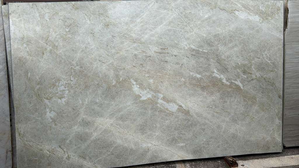 Gray stone tile slab with subtle veining and a rough unfinished edge
