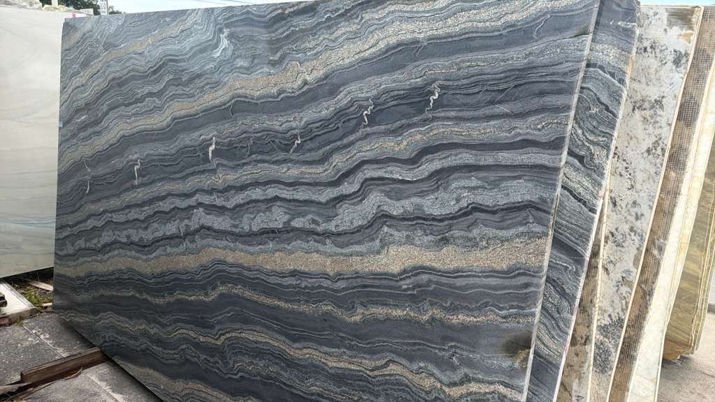 Large gray-and-white striped stone slab in a warehouse or yard