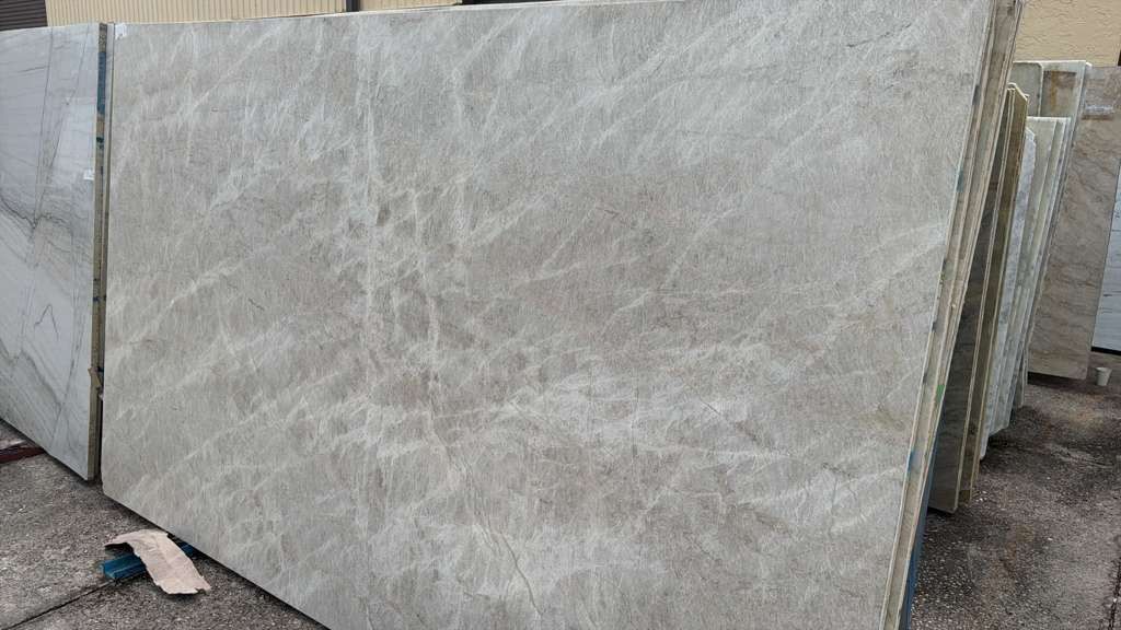 Large beige marble slabs stacked outdoors on a construction site