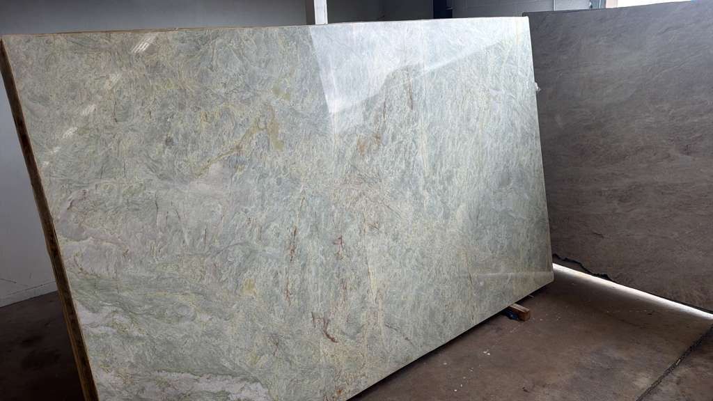 Large light-gray stone slab leaning against a wall in an industrial setting