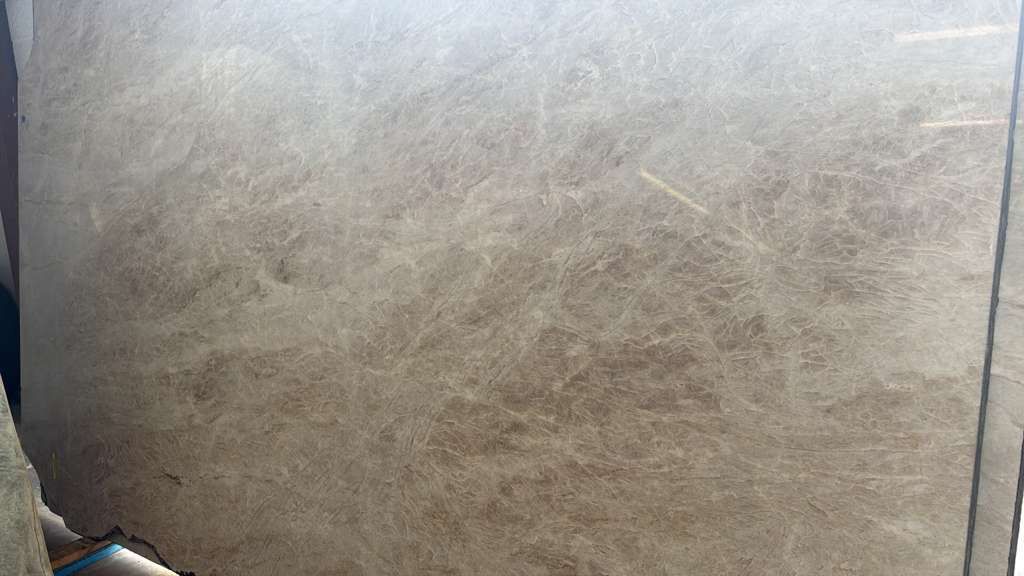 Close-up of a beige textured wall or carpet with a dark vertical edge on the right.