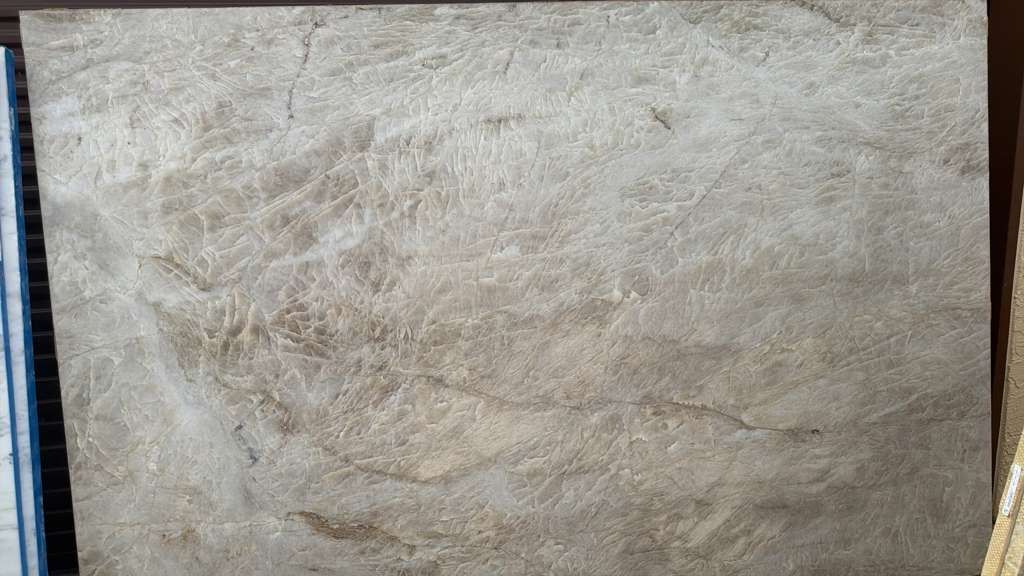 Close-up of a beige textured fabric surface with subtle wrinkling and woven pattern