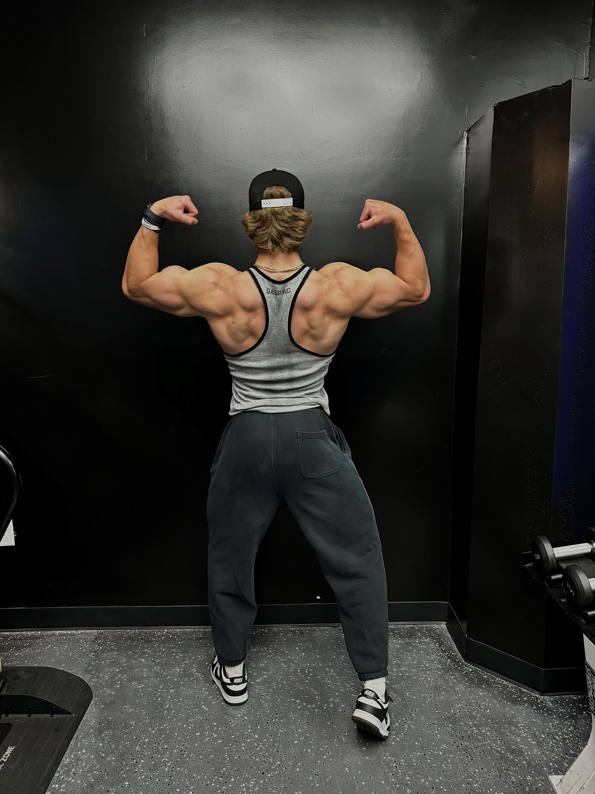 Jack Mulhern is flexing his muscles in a gym