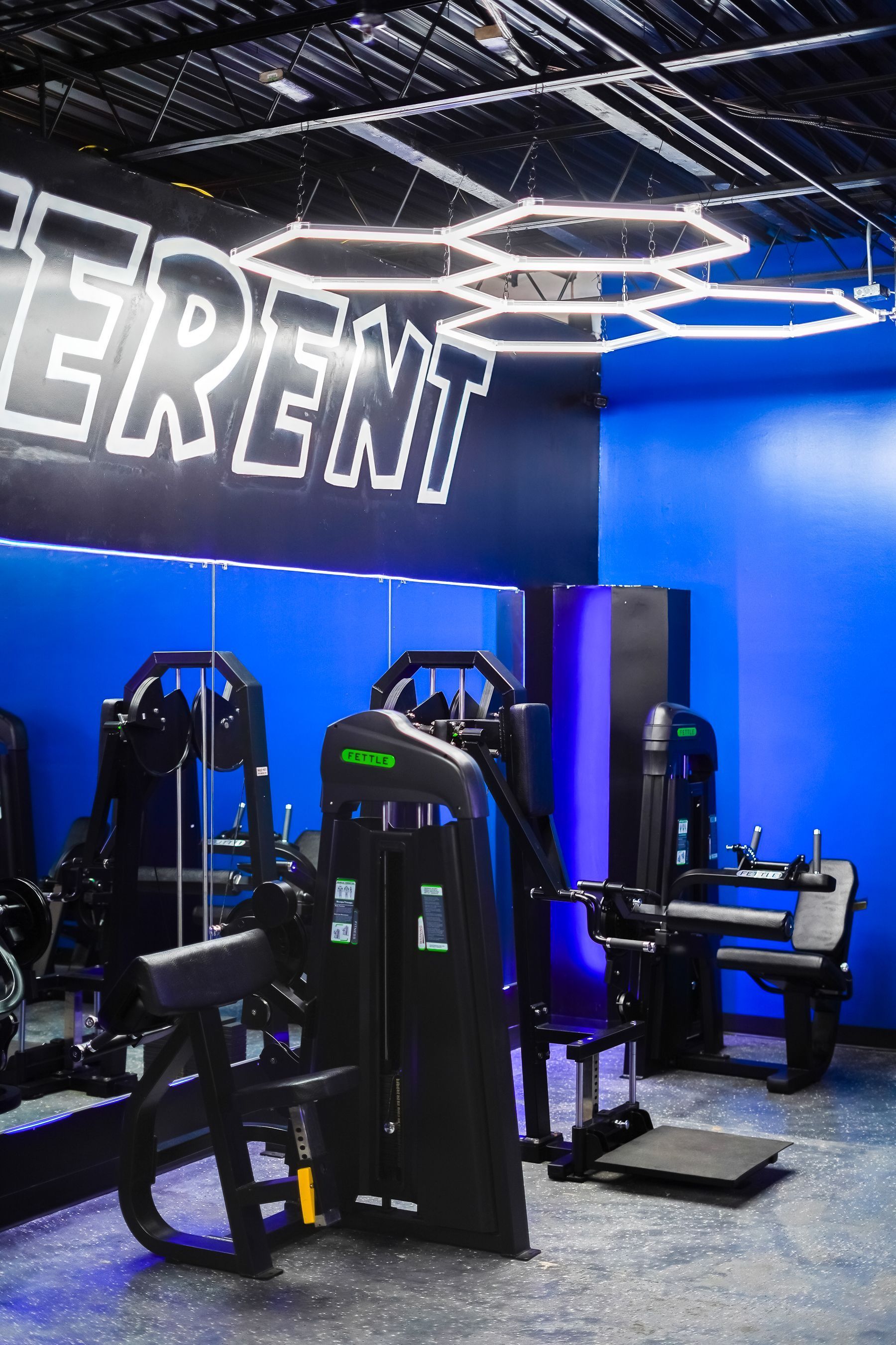 A gym with blue walls and a lot of exercise equipment.