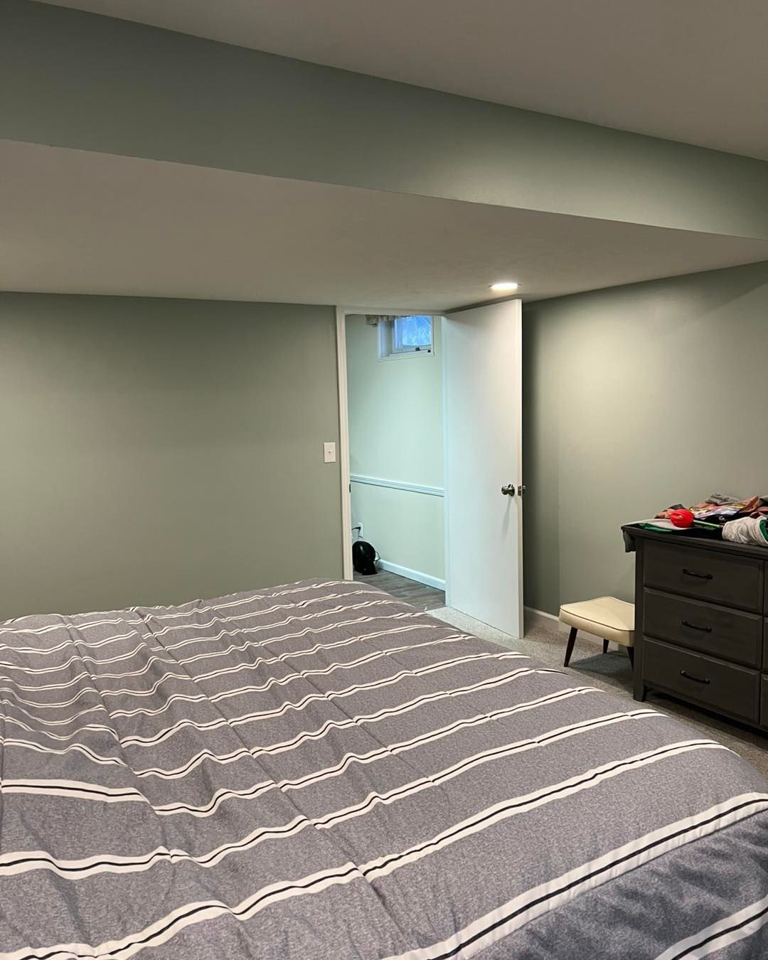A bedroom with a large bed and a dresser.