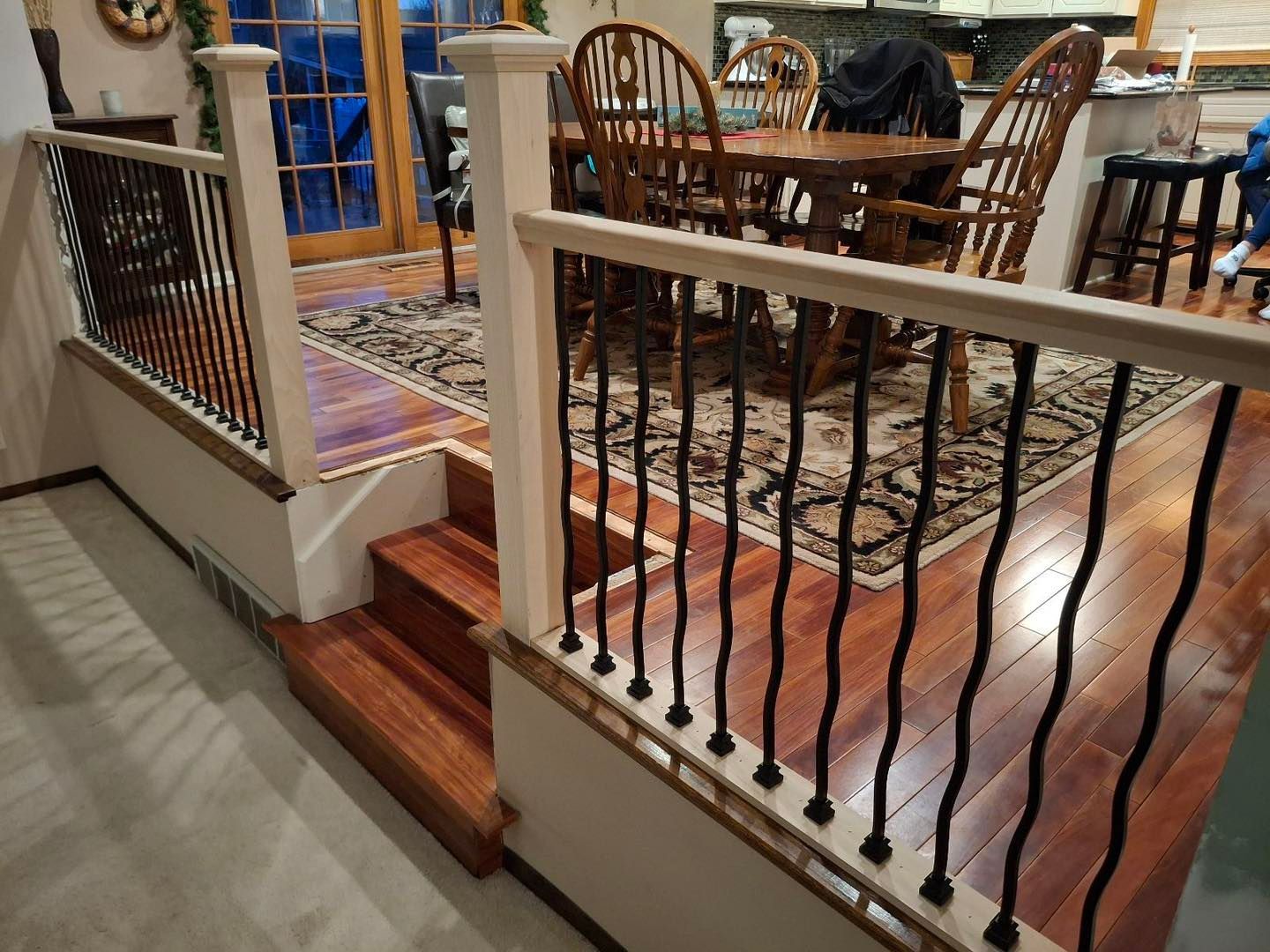 A staircase leading to a dining room with a table and chairs.