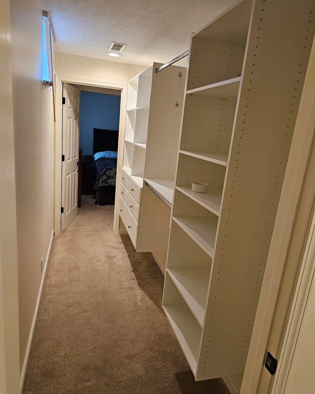 A walk-in closet with lots of shelves and drawers in a bedroom.