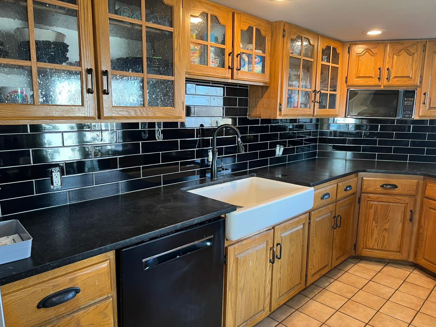 A kitchen with wooden cabinets and black counter tops.