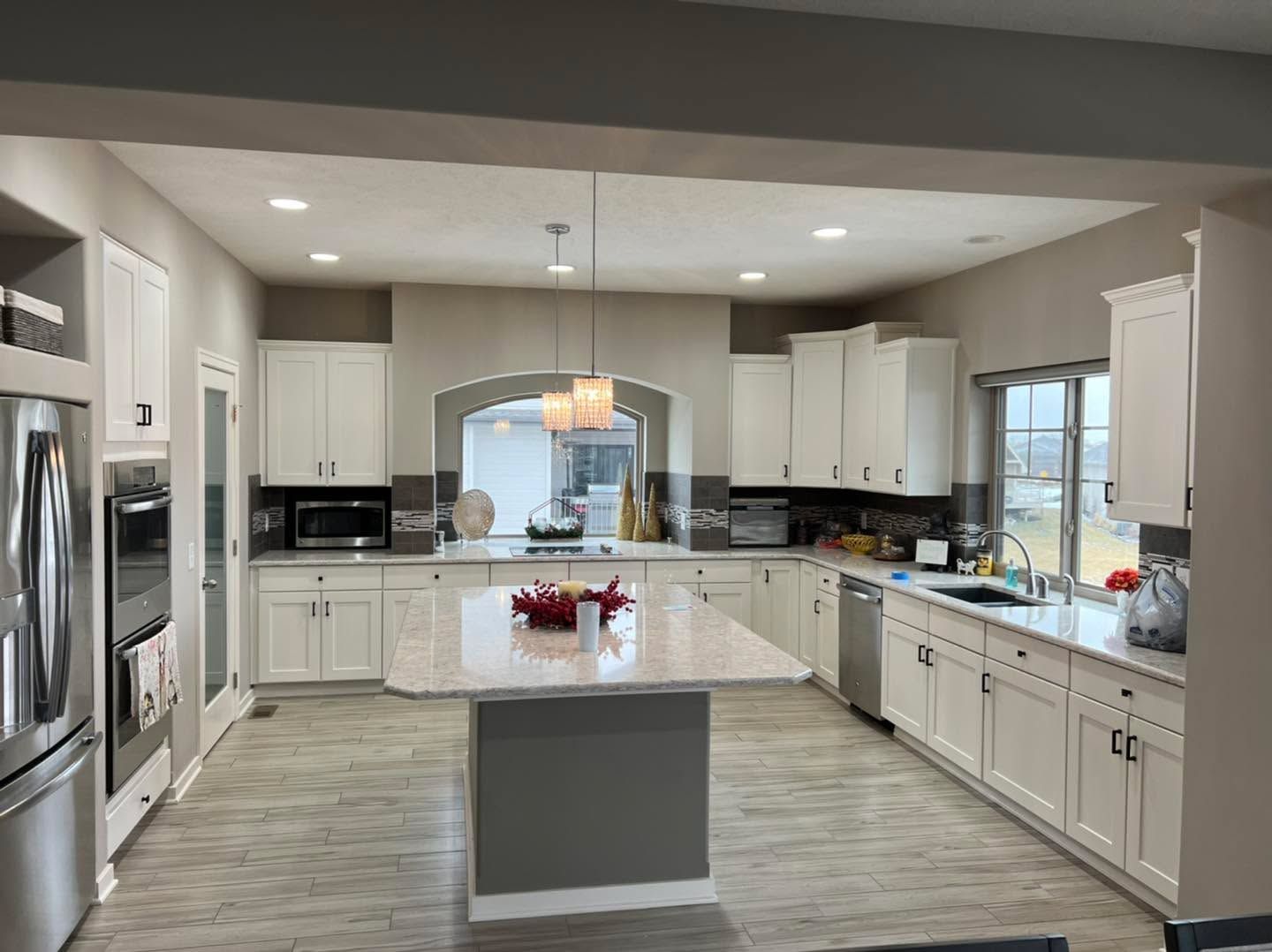 A large kitchen with white cabinets and stainless steel appliances.