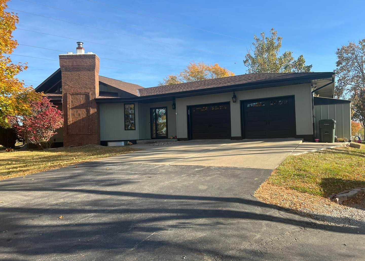 A large house with two garages and a chimney.