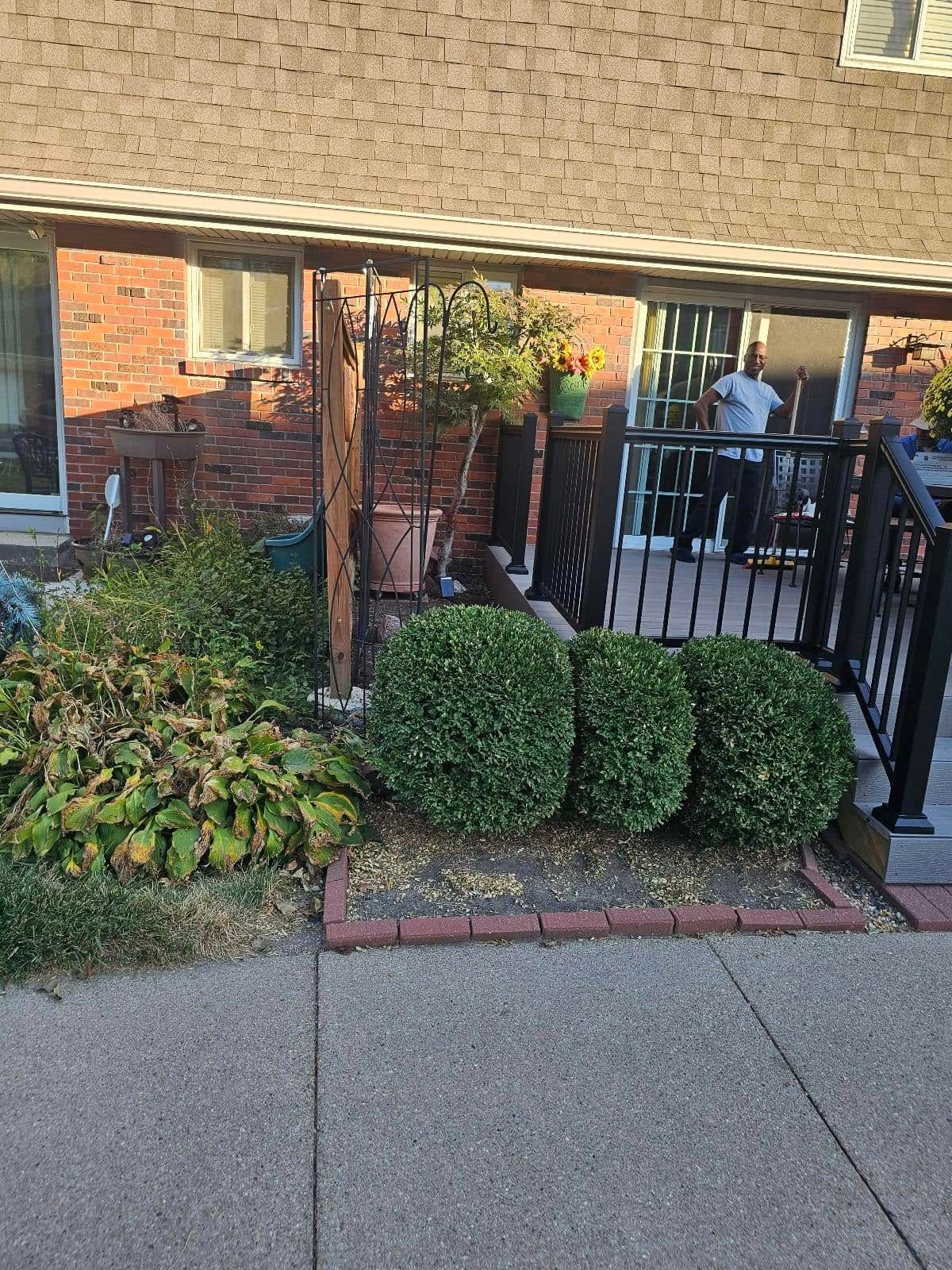 A man is standing on a porch next to a house.