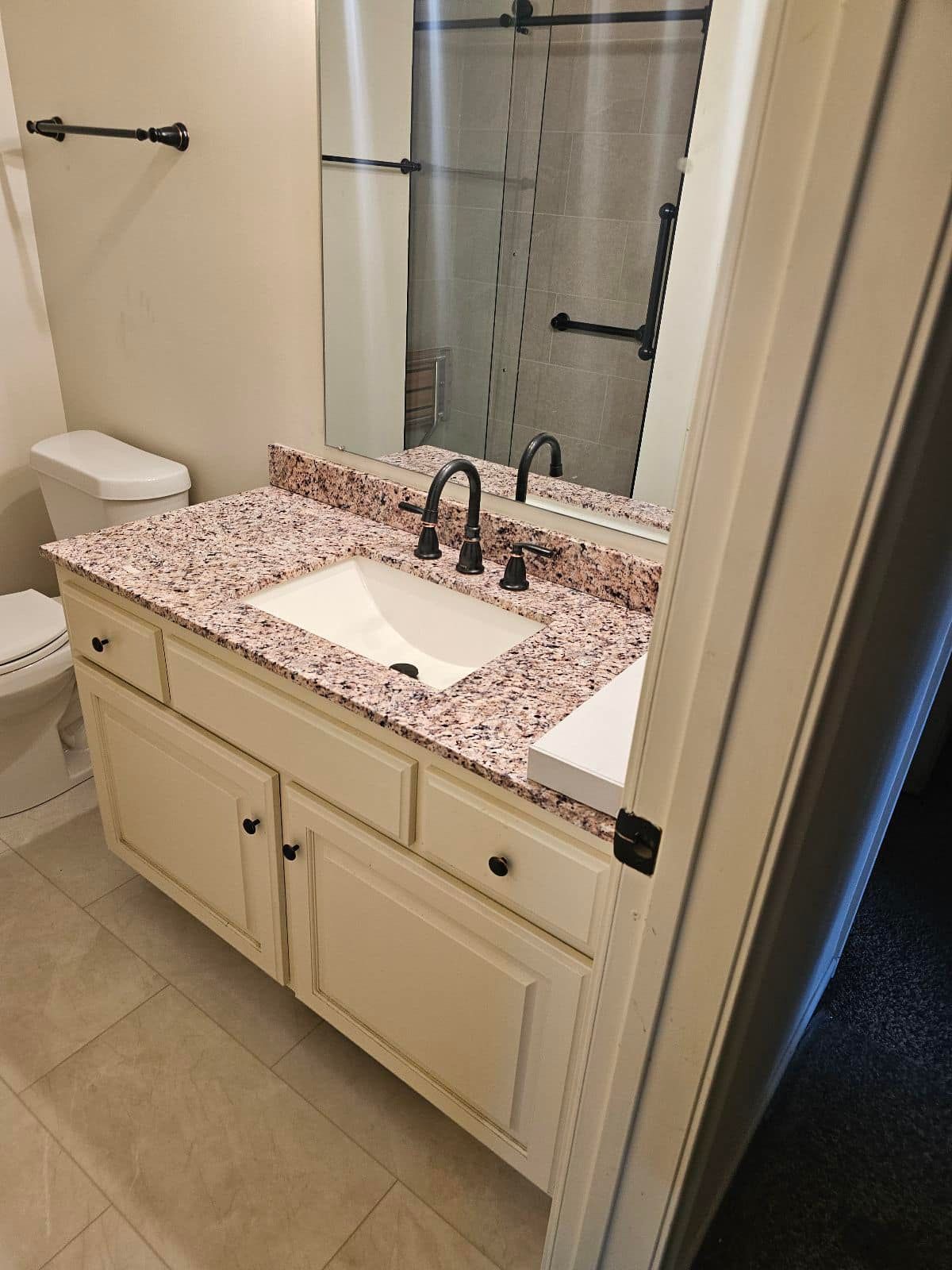 A bathroom with a sink, toilet and mirror.