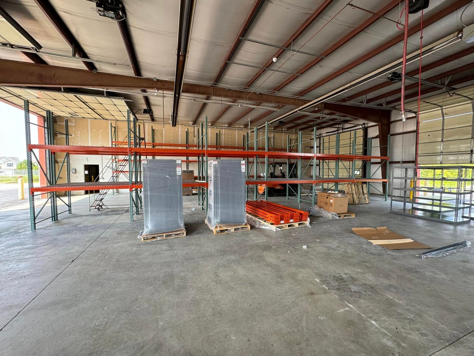 A large warehouse with lots of shelves and pallets.