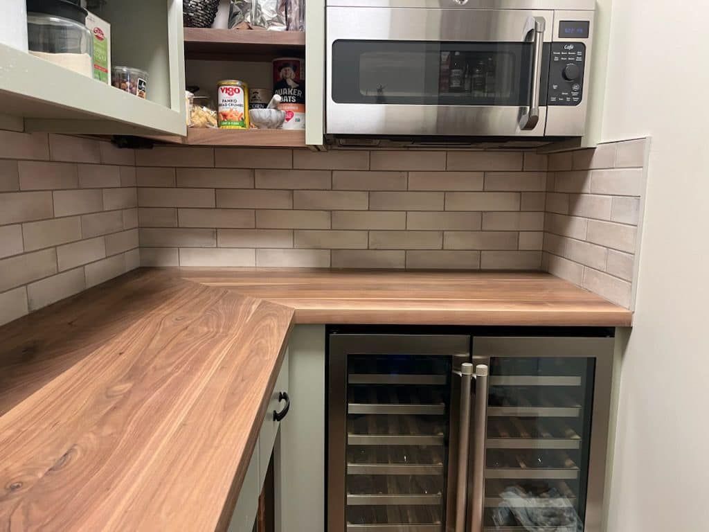 A kitchen with a microwave and a wine cooler.