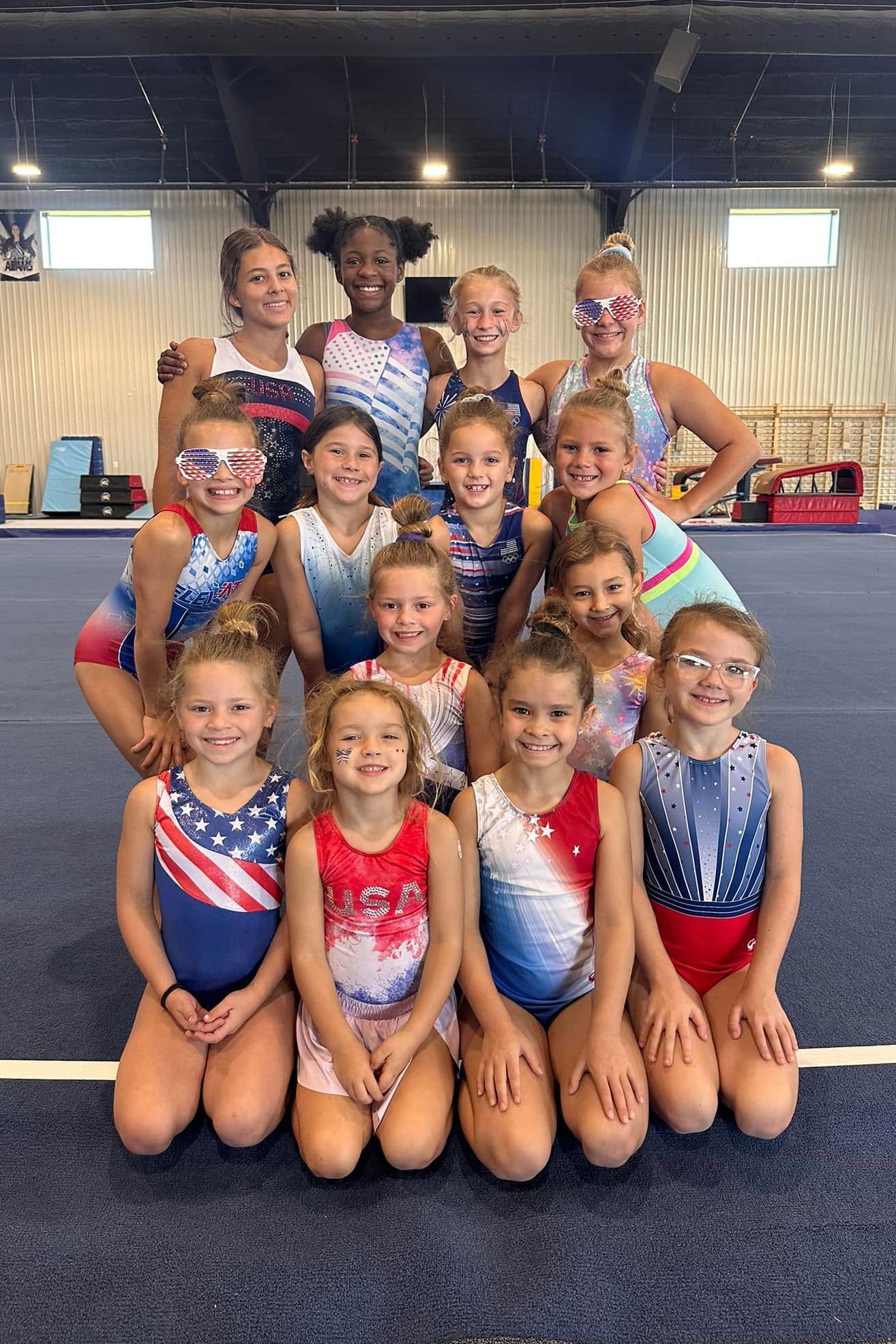 A group of young girls are posing for a picture in a gym.