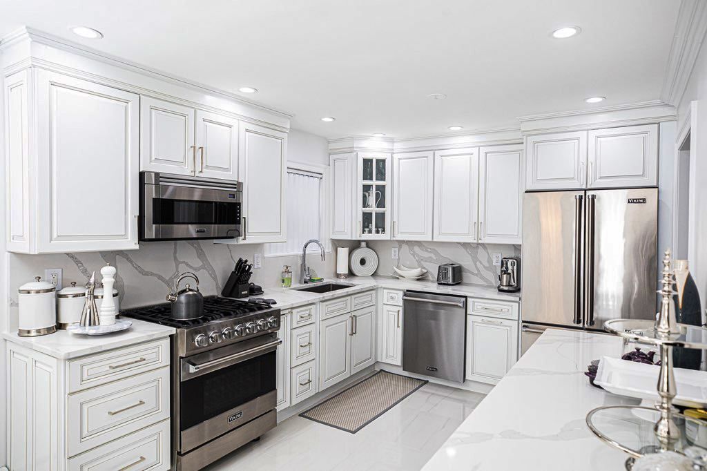 A kitchen with white cabinets and stainless steel appliances