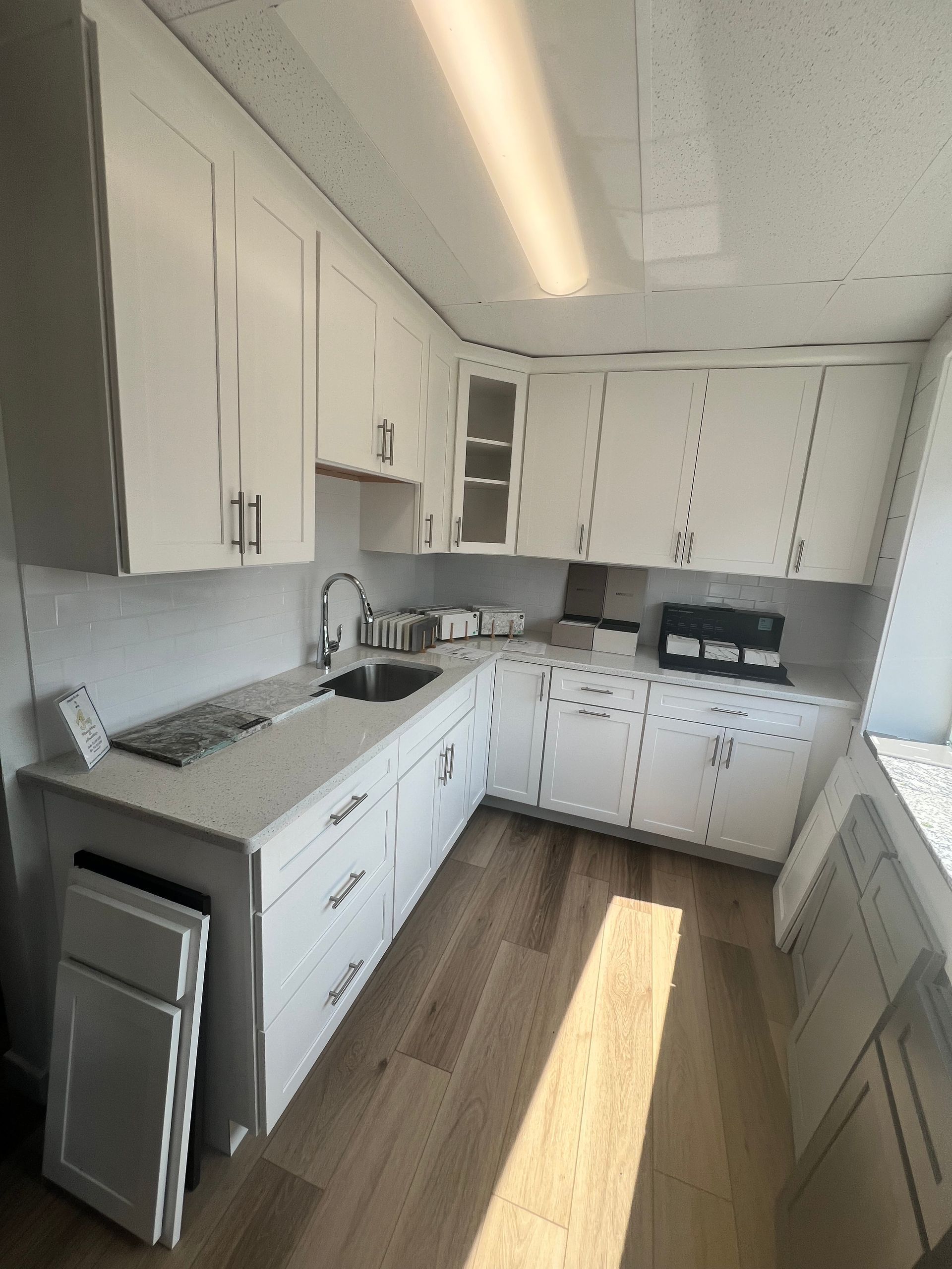 A kitchen with white cabinets and a sink.