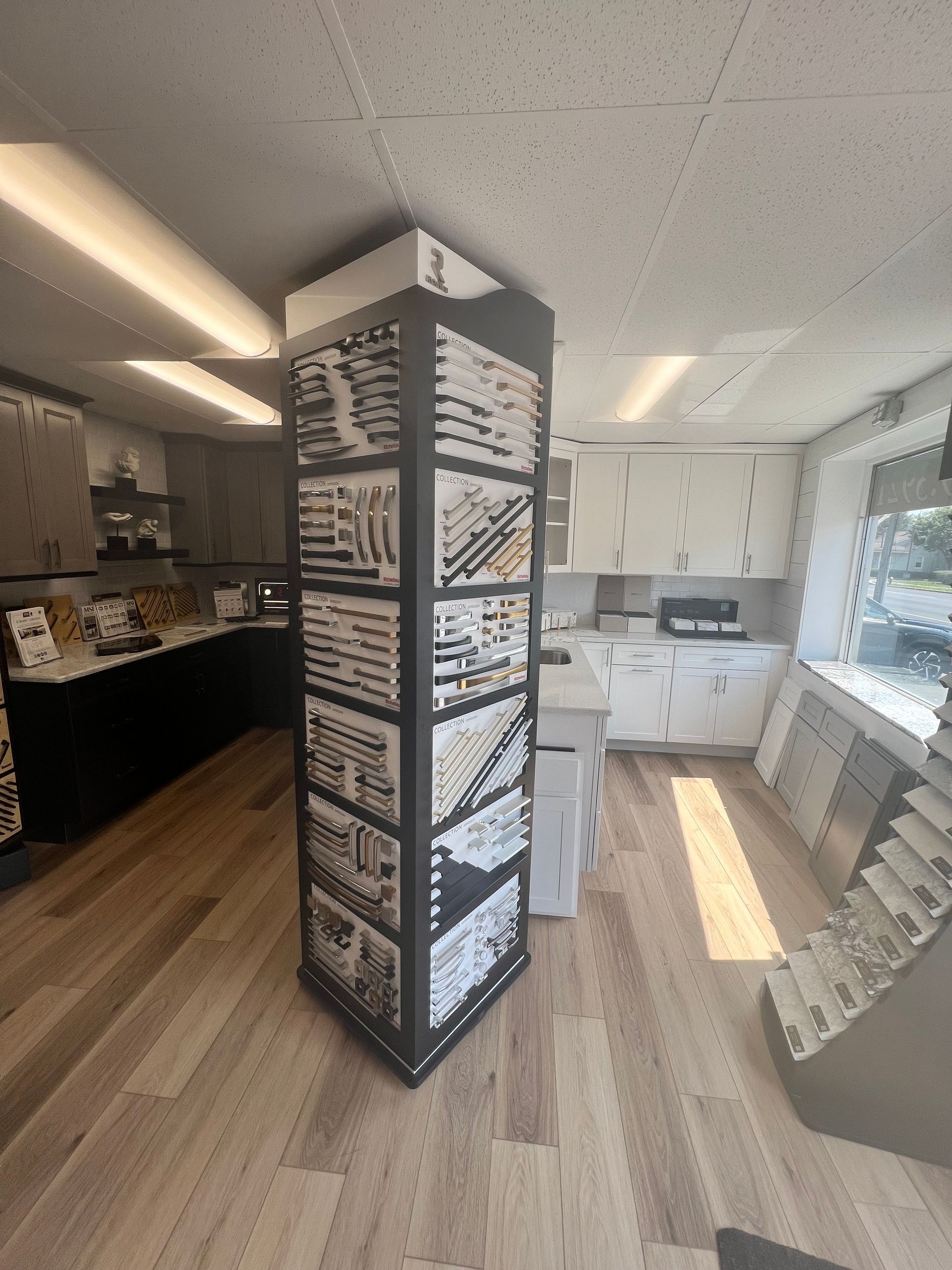 A kitchen with a display of tiles and hardware in a showroom.