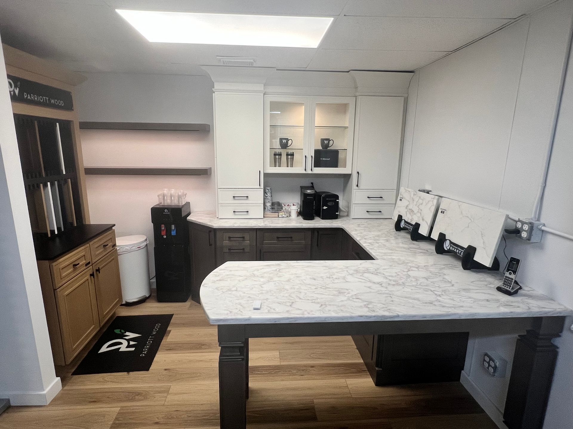 A kitchen with a marble countertop and wooden floors.
