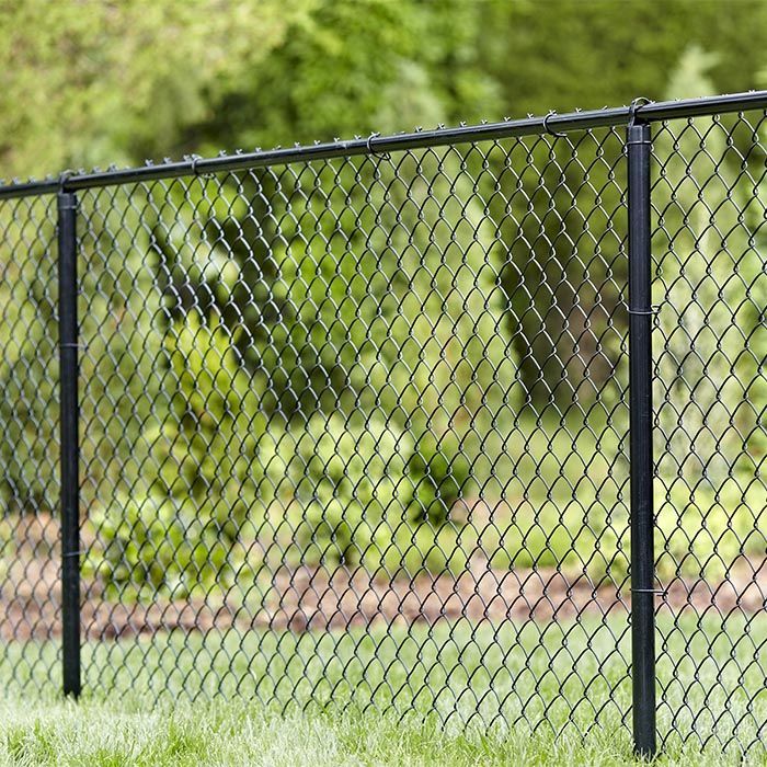 A chain link fence is sitting on top of a lush green lawn.