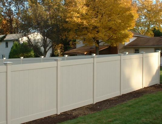 A white fence with a house in the background