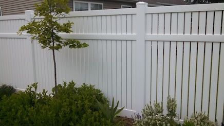 A white fence with a tree in the middle of it.