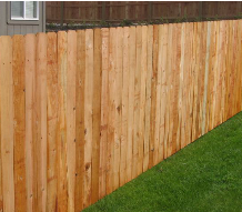 A wooden fence is sitting on top of a lush green lawn.