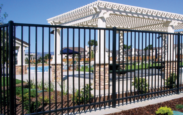 A black metal fence surrounds a pool area