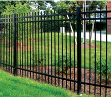 A black metal fence surrounds a lush green yard.