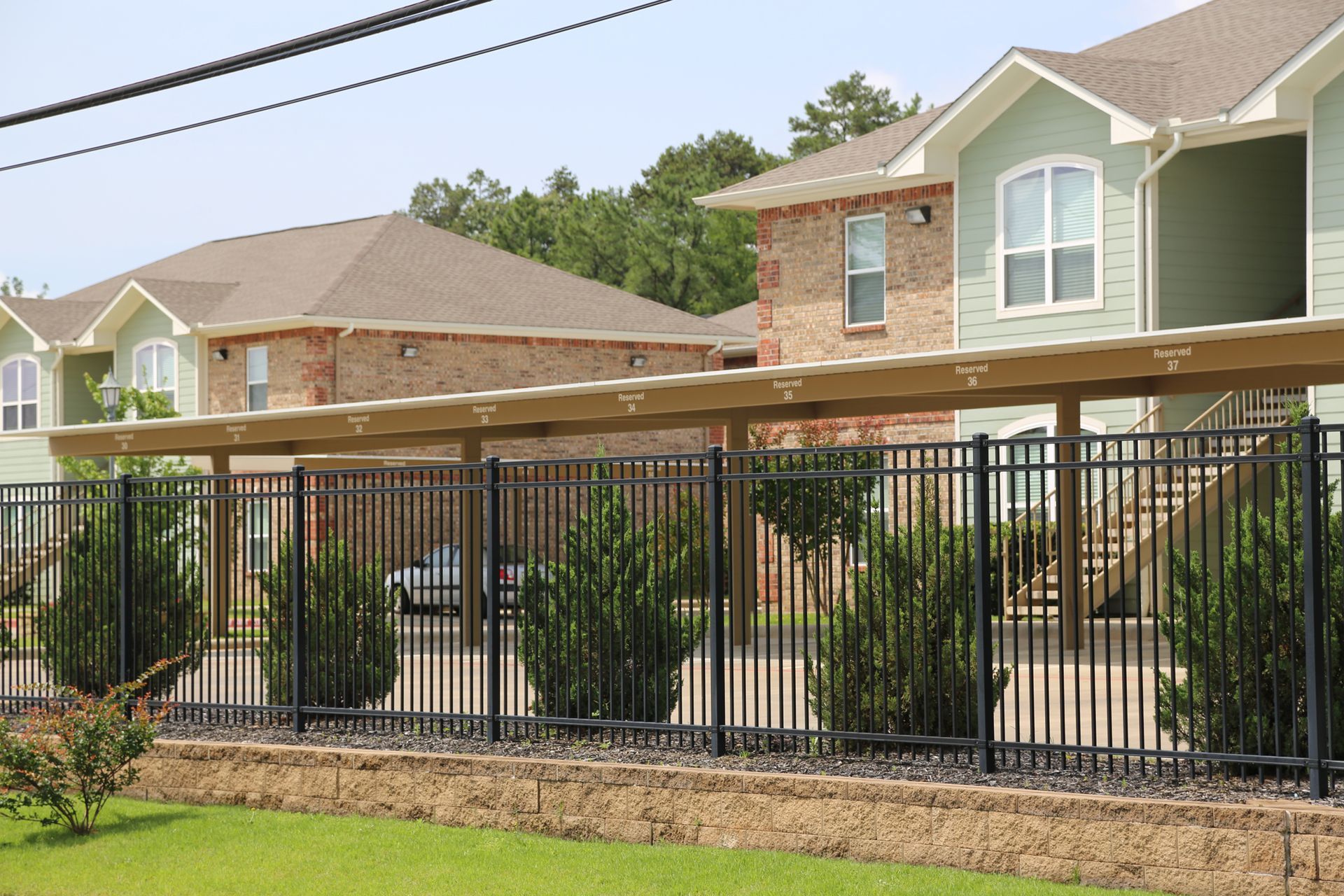 A fence surrounds a row of apartment buildings