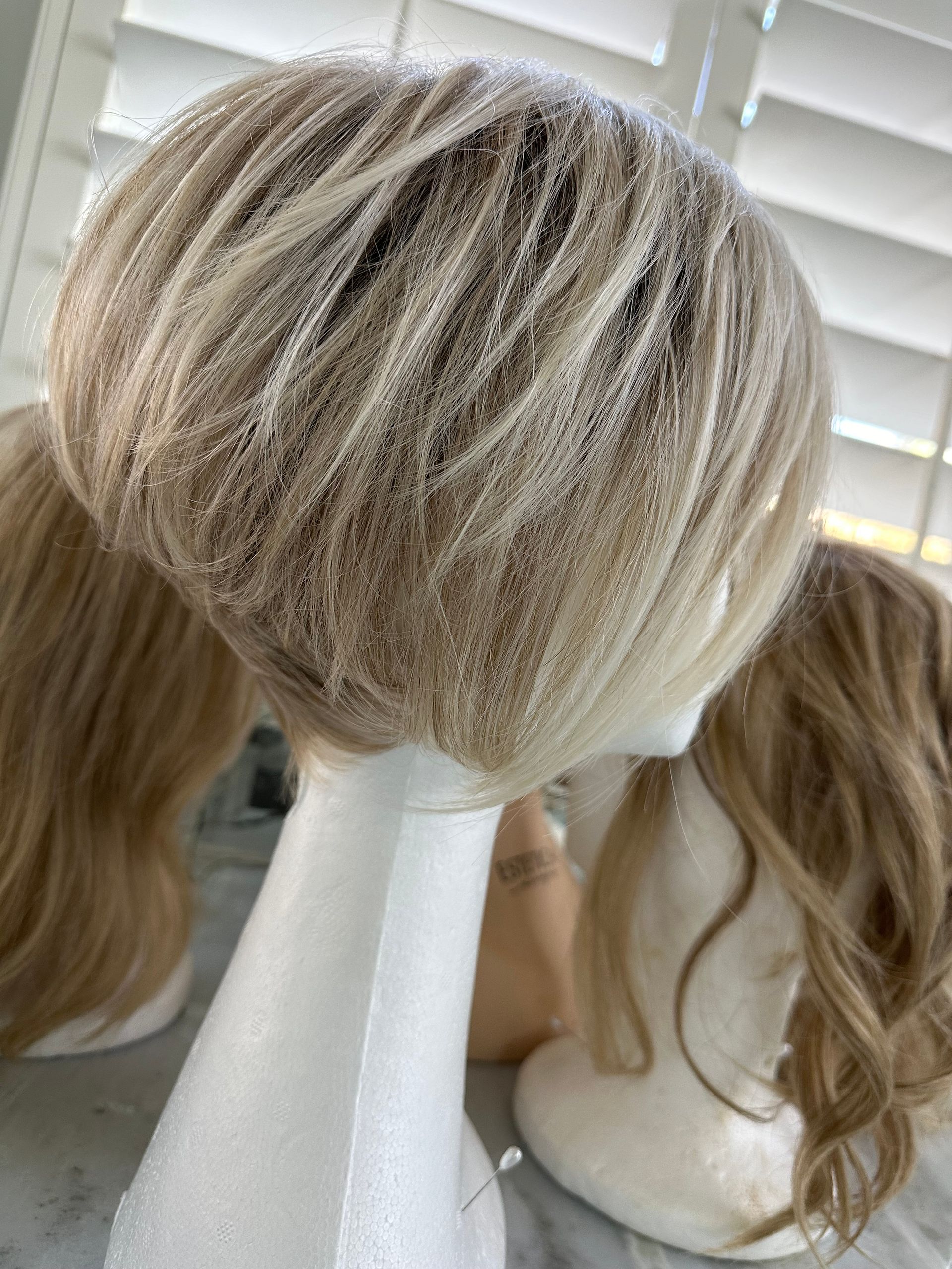A close up of a wig on a mannequin head.