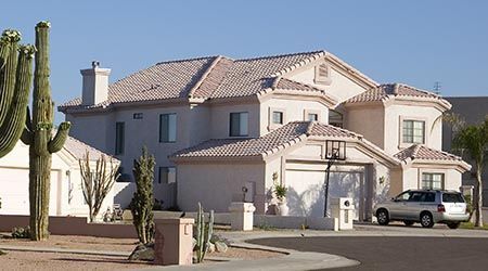 A large white house with a cactus in front of it