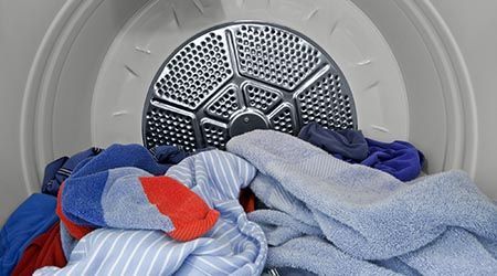 A pile of clothes is sitting inside of a dryer.