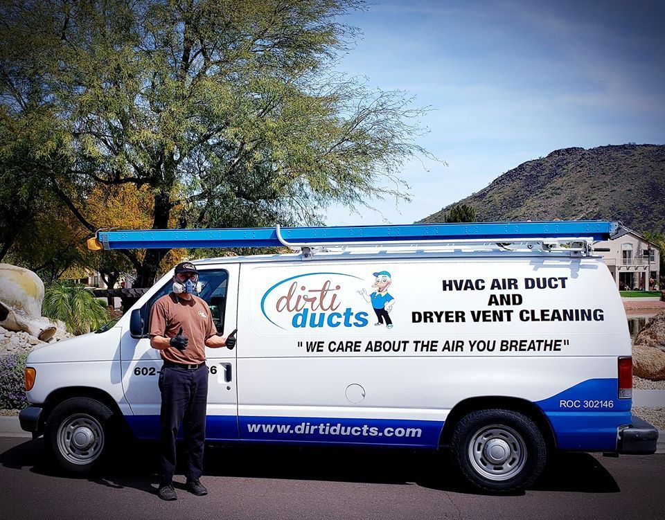 A man is standing in front of a van that says dirty ducts