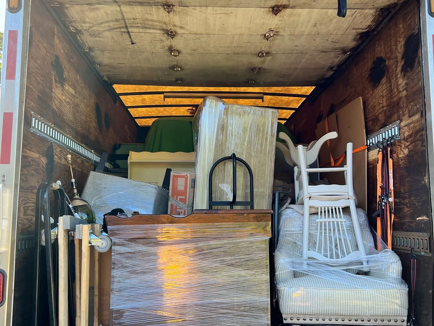 The inside of a moving truck filled with furniture and boxes.