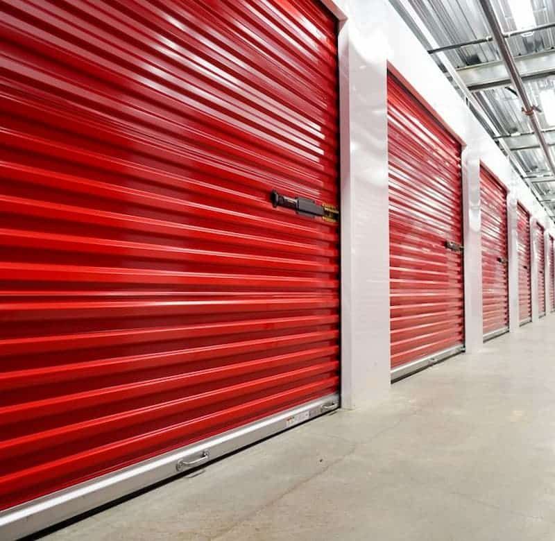 A row of red garage doors in a storage facility.