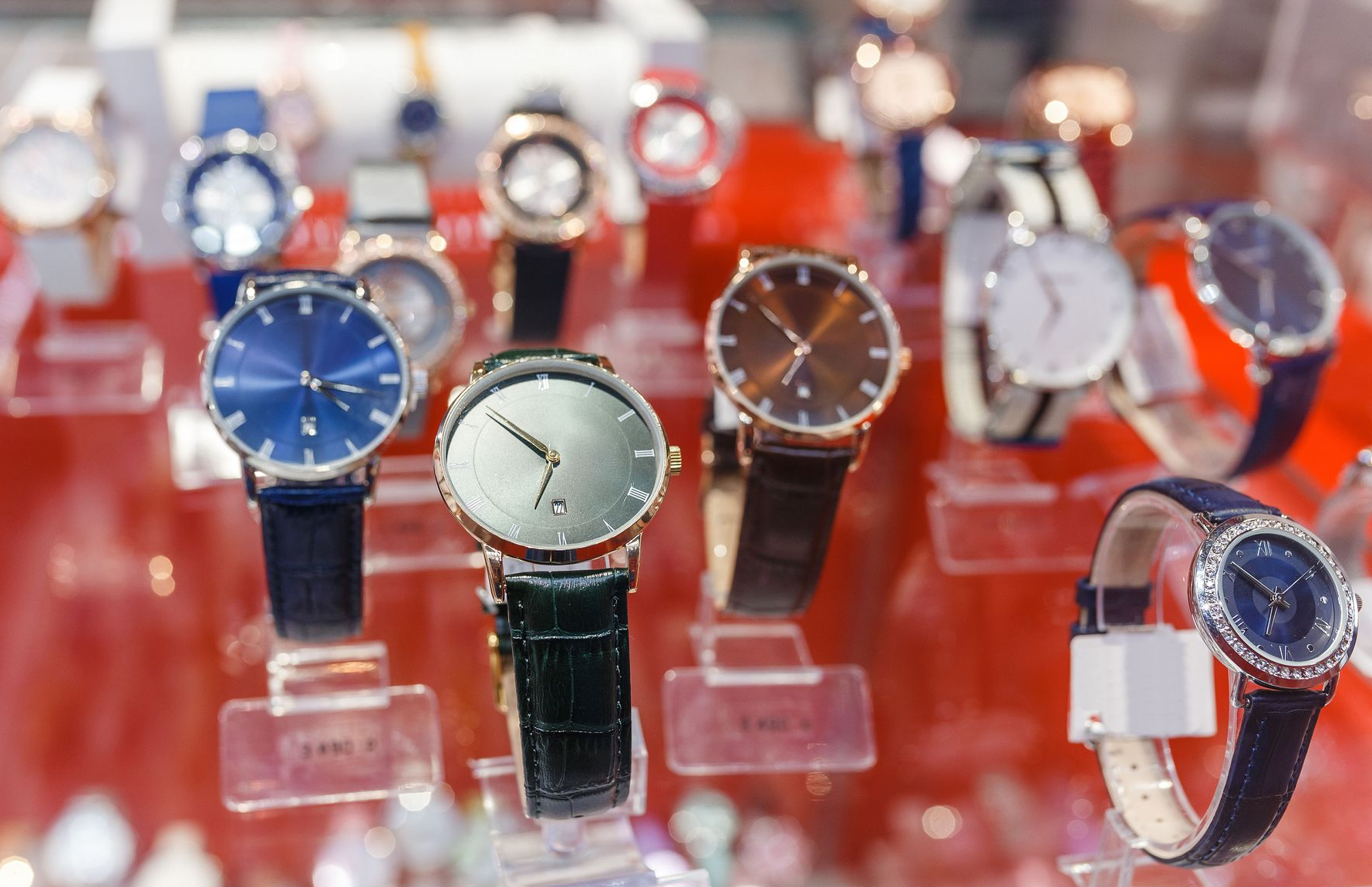 Display case of various wristwatches with different colored faces and straps.
